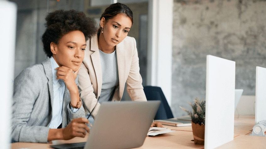 businesswomen-cooperating-while-working-on-laptop-tiny
